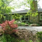  Large beams, a stone fireplace, warm pine floors and huge windows look over the pastures and beyond to the mountains at this equestrian estate