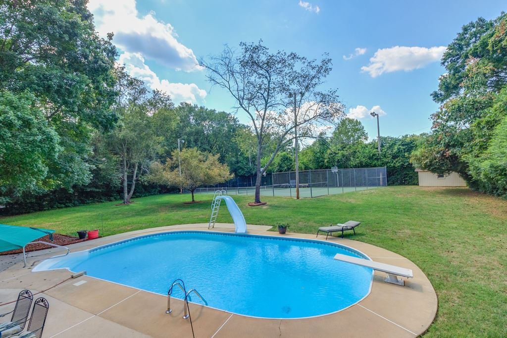 In-ground pool with slide and diving board at this Charlotte Mid-Century Modern Home.